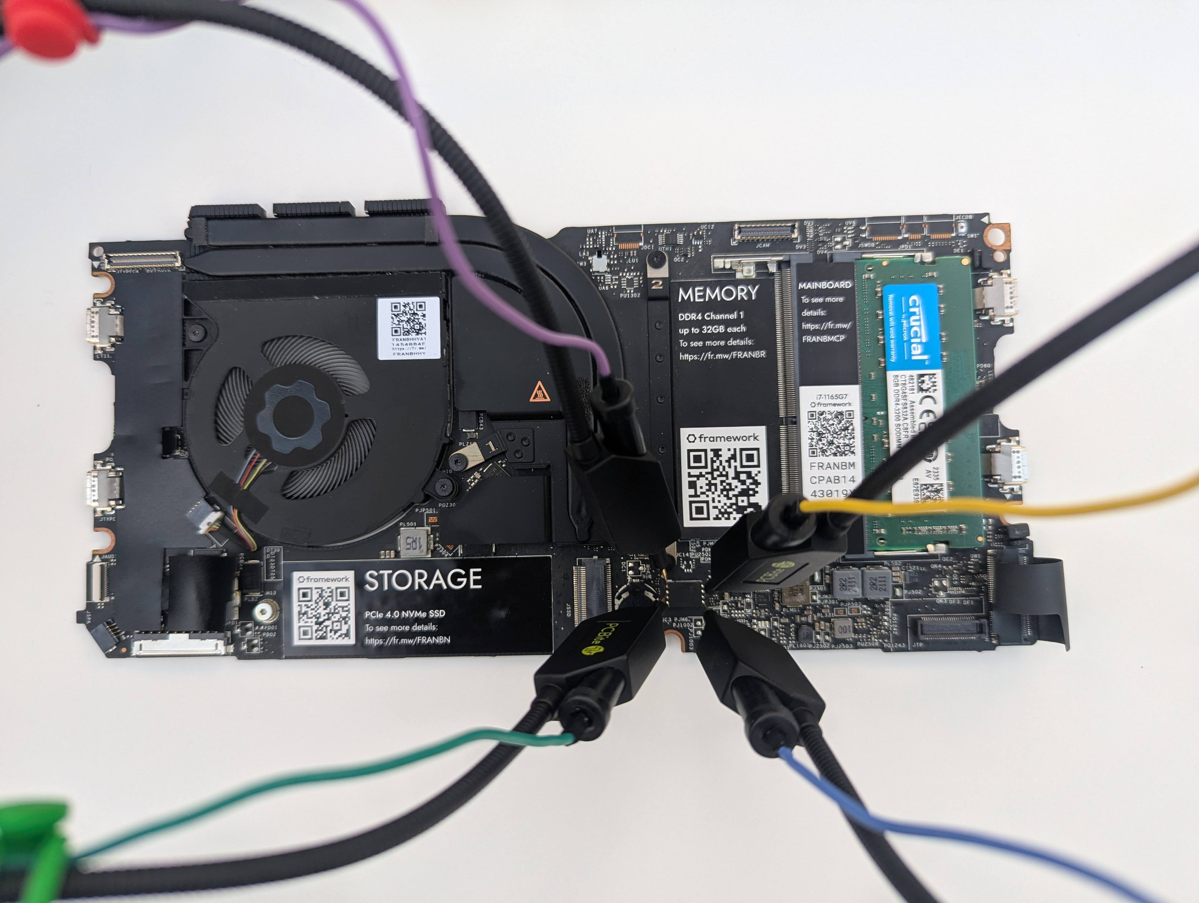 Photo showing the same motherboard with some test leads attached to the SPI flash rom